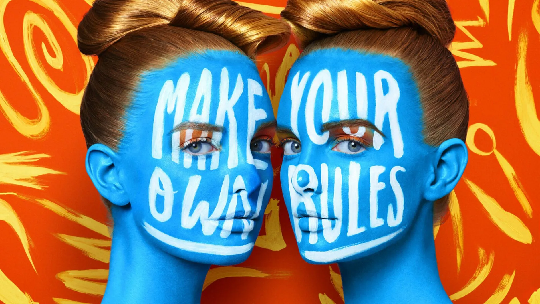 Immagine di due donne bionde in posizione speculare e con il viso dipinto di blu e un testo in bianco 'make your own rules'