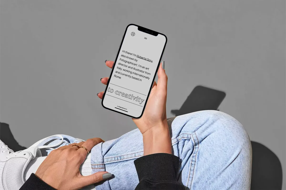 Mani di una ragazza con in mano uno smartphone che naviga sul sito dell'art director Roberta Soru