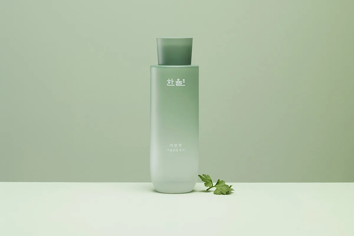 Immagine di una confezione con tonalità sfumate del verde del brand coreano HANYUL della linea Pure Artemisia Skin Care su sfondo verde chiaro.